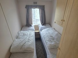 A bedroom with two single beds and a window at Number 186 Owens Caravan Park in Abergele