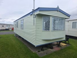 A caravan with windows and grass at Number 186 Owens Caravan Park, Abergele