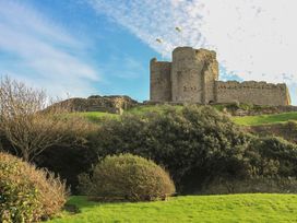 A castle with walls and flags surrounded by grass and bushes at Lodge 5 - Bron Eifion in Criccieth