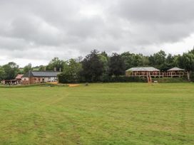 A grassy area with trees and buildings at Copper Suite Chulmleigh