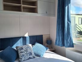 A bedroom with a bed and pillows at St Andrews Holiday Park - Taigh na Mara, St Andrews