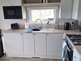 A kitchen with a sink, microwave and kettle at St Andrews Holiday Park - Taigh na Mara, St Andrews