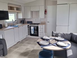 A kitchen with appliances and dining setup at St Andrews Holiday Park - Taigh na Mara in St Andrews