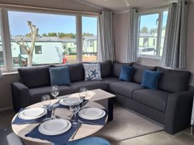 A living room with a sofa and dining table at St Andrews Holiday Park - Taigh na Mara, St Andrews