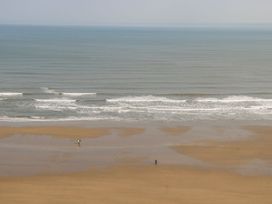 A beach scene with two people on the sand