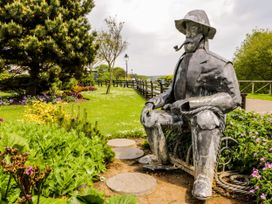 A statue in a garden with flowers and a pathway at 5 Station Avenue 