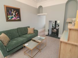 A living room with a green sofa and coffee table at 5 Station Avenue