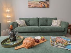 A living room with a green sofa and snacks at 5 Station Avenue