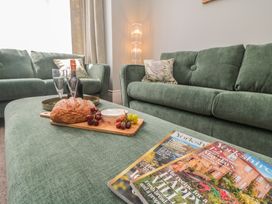 A living room with a sofa and magazines at 5 Station Avenue