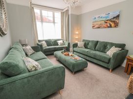 A living room with green sofas and coffee table at 5 Station Avenue