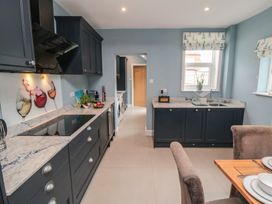 A kitchen with cabinets, sink, and dining table at 5 Station Avenue