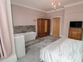 A bedroom with a bathtub and wardrobes at 5 Station Avenue