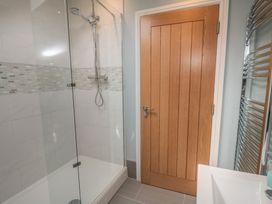 A bathroom with a shower and wooden door at 5 Station Avenue