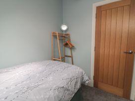 A bedroom with a bed and a clothes rack at 5 Station Avenue