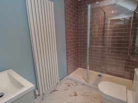 A bathroom with shower, toilet, wash basin, and radiator at 5 Station Avenue
