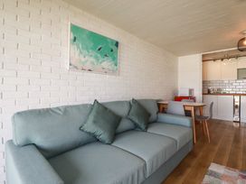 A living room with a sofa and dining area at A5 Bay Apt.