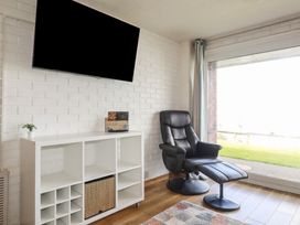 A living room with a television and an armchair at A5 Bay Apt.