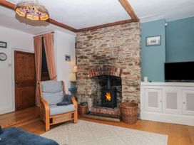 A living room with a fireplace and a sofa at Tiller Cottage in Dartmouth