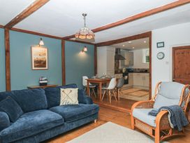 A living room with a sofa and dining area at Tiller Cottage in Dartmouth