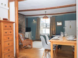 A dining room with a table and chairs at Tiller Cottage in Dartmouth