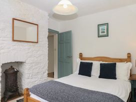 A bedroom with a bed and furniture at Tiller Cottage Dartmouth
