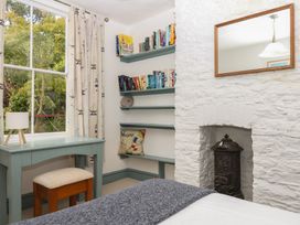A bedroom with a desk and bookshelf at Tiller Cottage in Dartmouth