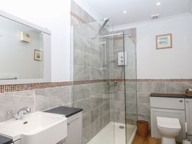 A bathroom featuring a sink, shower, and toilet at Tiller Cottage in Dartmouth