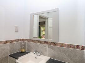 A bathroom with a sink and mirror at Tiller Cottage Dartmouth