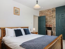 A bedroom with a bed and bedside table at Tiller Cottage in Dartmouth