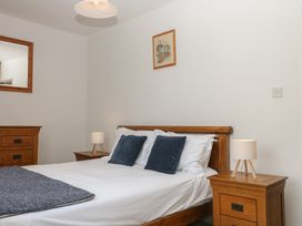 A bedroom with a bed and furniture at Tiller Cottage in Dartmouth