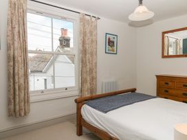 A bedroom with a bed and dresser at Tiller Cottage in Dartmouth