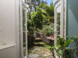 A view of a garden through open doors at Tiller Cottage in Dartmouth
