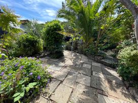 A garden with paving stones and plants at Tiller Cottage in Dartmouth