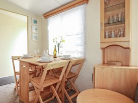A dining room with a table set for meals at Beech Lodge in Wadebridge