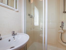A bathroom with a sink and shower at Beech Lodge in Wadebridge