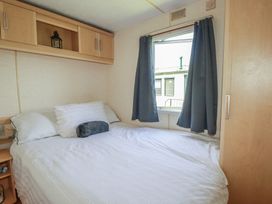 A bedroom with a bed and window at Beech Lodge in Wadebridge
