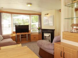 A living room with a television and sofa at Beech Lodge in Wadebridge