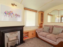 A living room with a sofa and artwork at Beech Lodge in Wadebridge