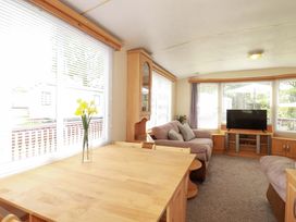 A living room with a sofa and television at Beech Lodge in Wadebridge