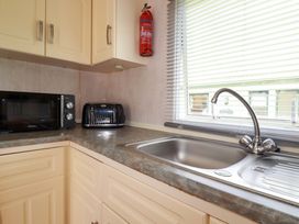 A kitchen with a microwave, toaster, and sink at Beech Lodge in Wadebridge