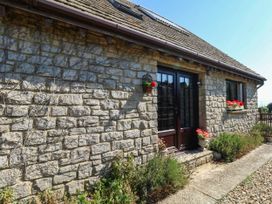 A stone wall with flowers and a pathway at Dunvant in Swanage