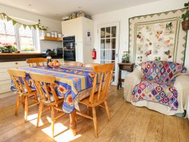A kitchen with a dining table and chairs at Dunvant in Swanage