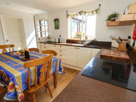A kitchen with a table and chairs at Dunvant in Swanage