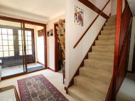 A hallway with a staircase and a front door at Dunvant in Swanage