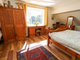 A bedroom with a bed and clothing storage at Dunvant in Swanage