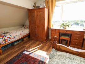 A bedroom with a bed and wardrobe at Dunvant in Swanage