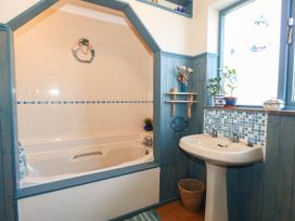 A bathroom with a bathtub and sink at Dunvant in Swanage