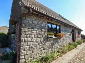A stone cottage with flower boxes and a pathway at Dunvant in Swanage