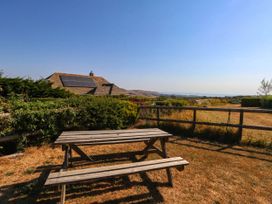 A garden with a table and house in the background at Dunvant in Swanage