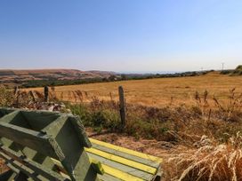 A view of a field with a bench and fence at Dunvant in Swanage